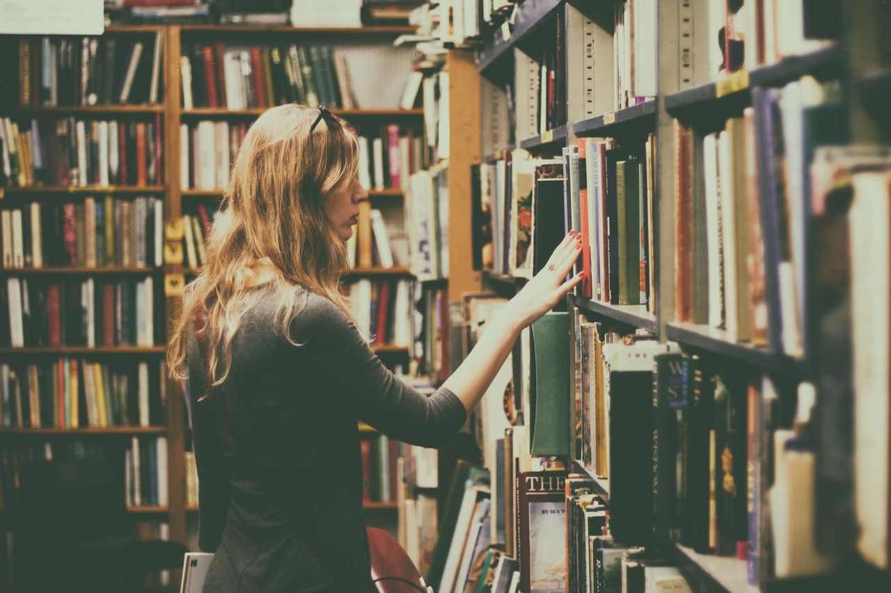 A young woman searches for a book to read.