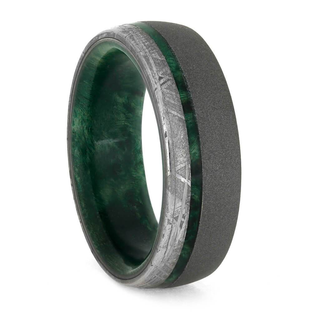 A picture of a men's wedding ring of green elder wood and meteorite.